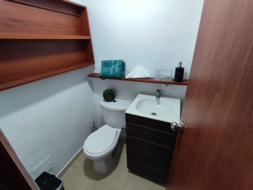 Baño pequeño con aseo y lavamanos en Habitación privada con vista a la ciudad, en Pereira