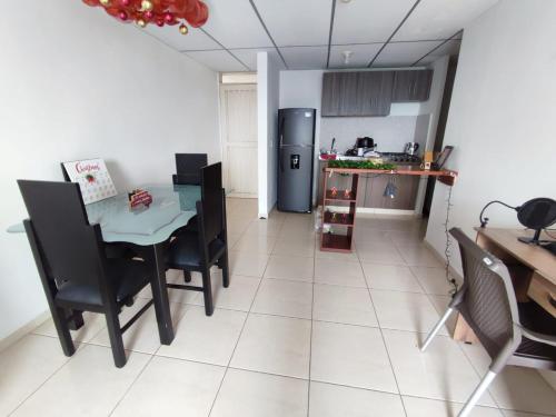 a kitchen with a table and chairs and a refrigerator at Habitación privada con vista a la ciudad in Pereira