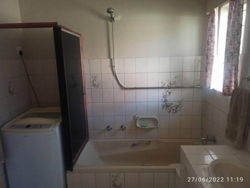 a bathroom with a bath tub and a sink at CHEZ BRUNO in Pretoria