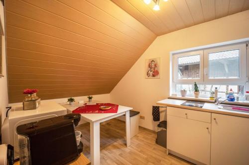 eine Küche im Dachgeschoss mit einem Tisch und einem Waschbecken in der Unterkunft Ferienwohnung im Grünen, 10 km RV, 30 km Bodensee, Küche Bad Balkon in Mochenwangen