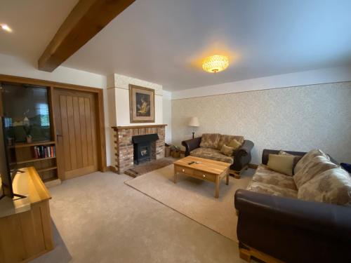 a living room with a couch and a fireplace at Mulberry Cottage near Goodwood in Chichester