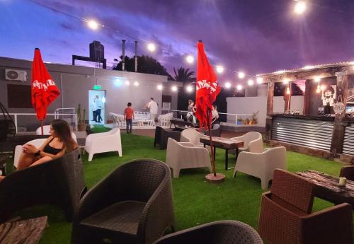 a group of people sitting in chairs on a patio at night at Privilegio Hostel in San Rafael