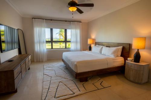 een slaapkamer met een bed en een groot raam bij The Country Club Residences at Grand Reserve in Rio Grande