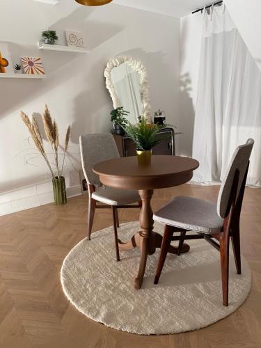 une table et des chaises en bois dans un salon dans l'établissement Agréable chambre d'hôte 70s au cœur de l'Alsace, à Bouxwiller