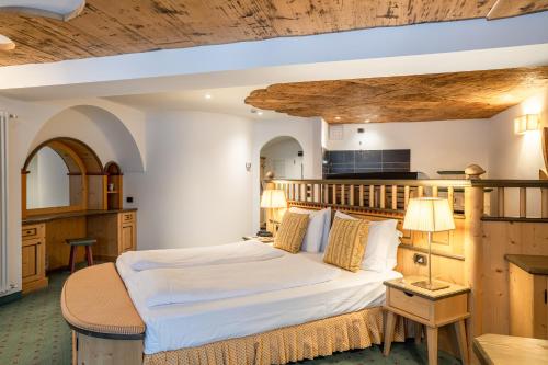 sypialnia z dużym łóżkiem w pokoju w obiekcie Croce Bianca Leisure & Spa Hotel w mieście Canazei