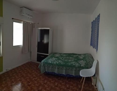 Dormitorio pequeño con cama y nevera en Nada en Buenos Aires