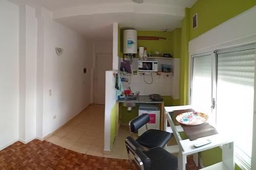 Habitación con cocina con paredes verdes y silla. en Nada en Buenos Aires