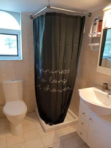 a bathroom with a black shower curtain with the words timelines a former answer at Sunny mountain view apartment with free parking in Rhodes Town