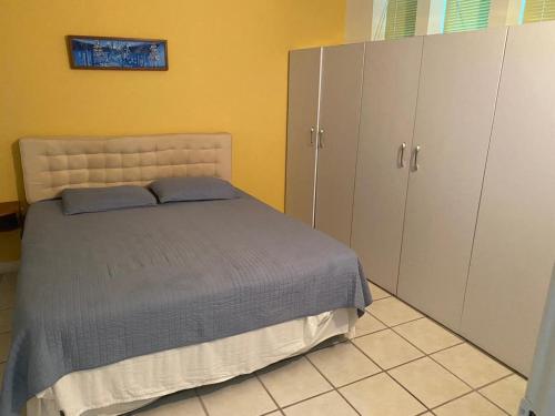 Pampatar的住宿－Bahia Dorada 1 habitación，一间卧室配有一张床和一些橱柜