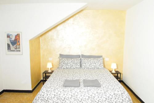 ヴェッツァーノ・リーグレにあるLa Pergolaのベッドルーム1室(大型ベッド1台、ランプ2つ付)