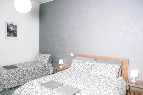 a bedroom with two beds and a gray wall at La Pergola Private Parking in Vezzano Ligure