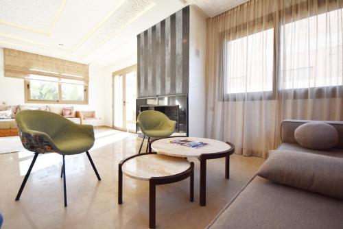 sala de estar con sofá, sillas y mesa en Villa Délice, en Marrakech