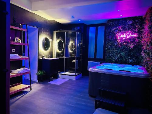 La salle de bains est pourvue d'une baignoire et d'une douche avec des lumières violettes. dans l'établissement Love Room Suite Dirty Diana, à Aubagne