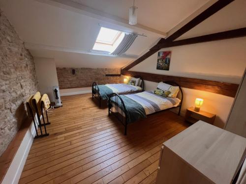 een slaapkamer met 2 bedden in een kamer bij Les Cerisiers Gîtes in Lezay