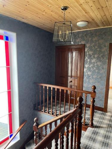 a staircase in a house with a chandelier at Bixter House - a spacious self-catering property in Twatt