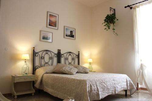a bedroom with a bed and two lamps and a window at Sicilia Nica - appartamento privato a Cinisi (PA) in Cinisi