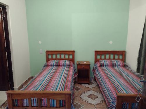 dwa łóżka siedzące obok siebie w pokoju w obiekcie Habitaciones Gabriel w mieście Termas de Río Hondo