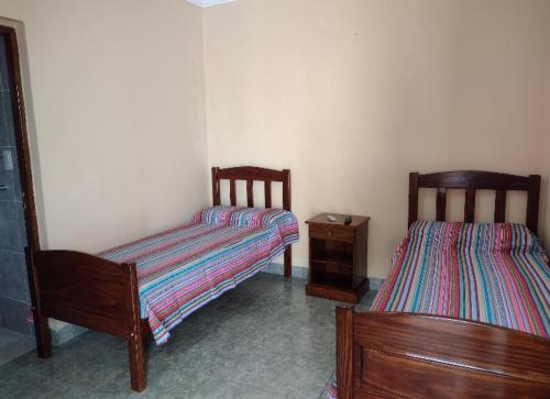 a room with two beds and a dresser in it at Habitaciones Gabriel in Termas de Río Hondo