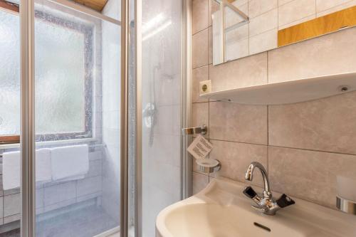 a bathroom with a sink and a shower at Schwüwong - Apartment 02 in Kelchsau