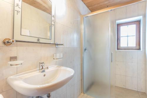 bagno bianco con lavandino e doccia di Schwüwong - Apartment 13 a Kelchsau