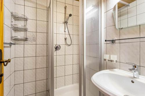 y baño con ducha y lavamanos. en Schwüwong - Apartment 21, en Kelchsau