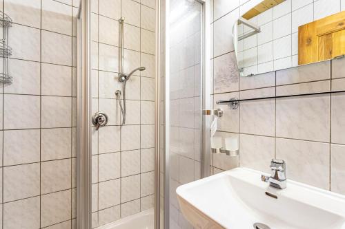 a bathroom with a sink and a shower at Schwüwong - Apartment 23 in Kelchsau