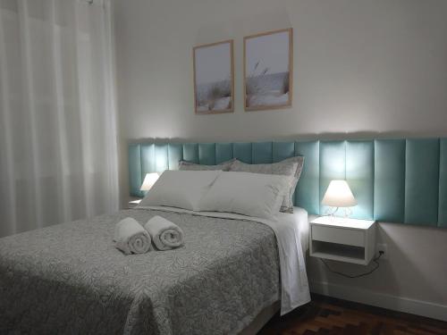um quarto com uma cama com duas toalhas em Aconchego e tranquilidade junto ao H. Mãe de Deus em Porto Alegre