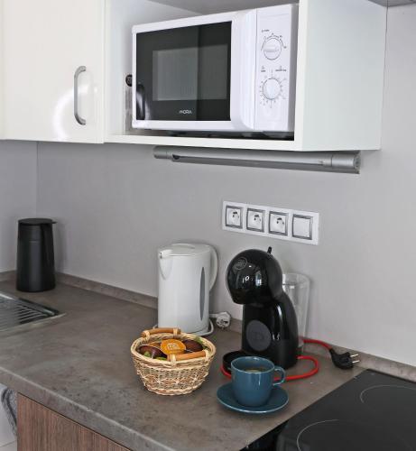 a kitchen counter with a microwave and a basket of food at Apartmány U Aloise in Dolní Morava