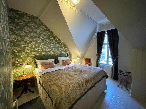 um quarto com uma cama grande num sótão em Jugend 1905 em Ålesund
