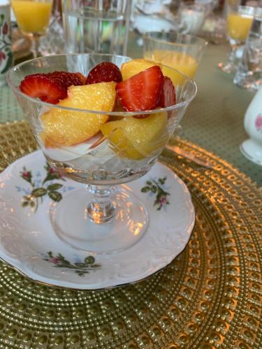 a bowl of fruit on a plate on a table at Green Oaks B&B in Niagara on the Lake
