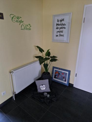 a room with a potted plant and a picture on the wall at Gästequartier Schlummerkasten in Sievern