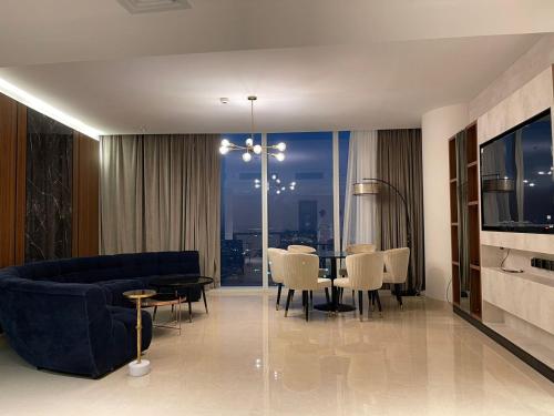 een woonkamer met een bank en een tafel met stoelen bij Raffal Tower Apartment in Riyad