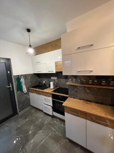 a kitchen with white cabinets and a black stove at Privát u Zdenky in Tvrdošín