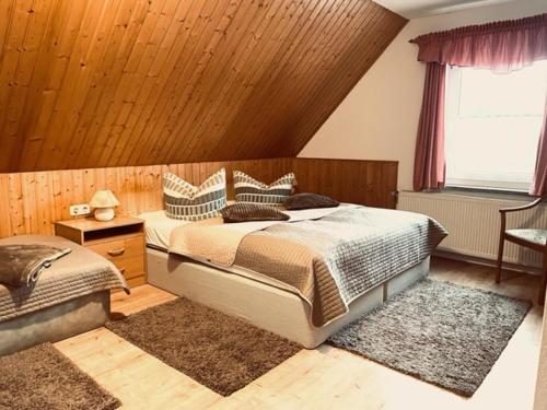 een slaapkamer met een groot bed en een raam bij Pension Buschmühle in Ohorn