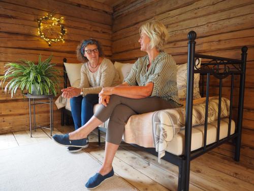 due donne più grandi sedute su un letto in una stanza di Stabburet, Lensmannsgården a Namsos
