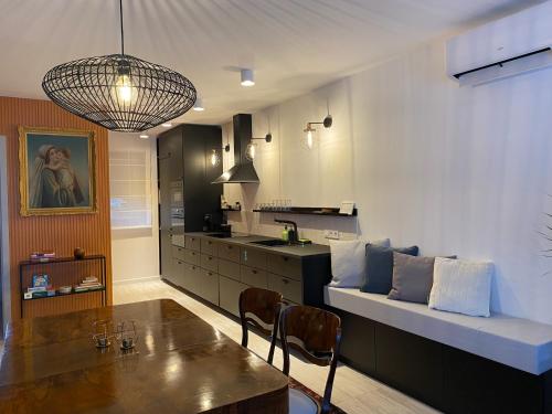uma cozinha com um sofá e uma mesa num quarto em Fotel Dunakanyar em Nagymaros