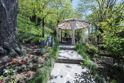 a garden with a gazebo and some flowers at Agriturismo La Fonte Di Mariella in Gravedona