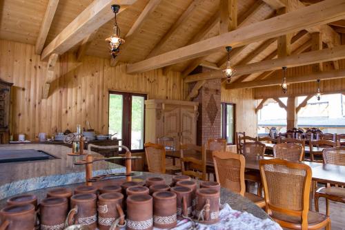 Conacul Baciu في فوندو مولدوفي: غرفة بها طاولات وكراسي وسقوف خشبية