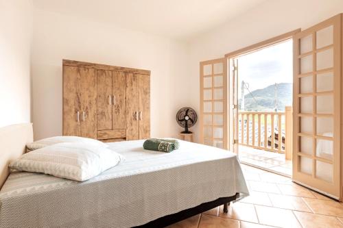 Un dormitorio con una cama grande y una ventana grande. en Casa de Campo Piscina Aquecida Atibaia, en Atibaia