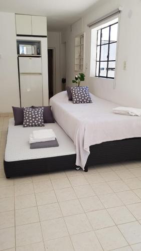 a bedroom with two beds with pillows and a window at Depto Gales, a 1 cuadra del mar in Puerto Madryn