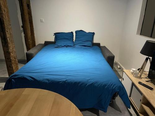 Una cama con almohadas azules encima. en Joli appartement quartier historique en Moulins