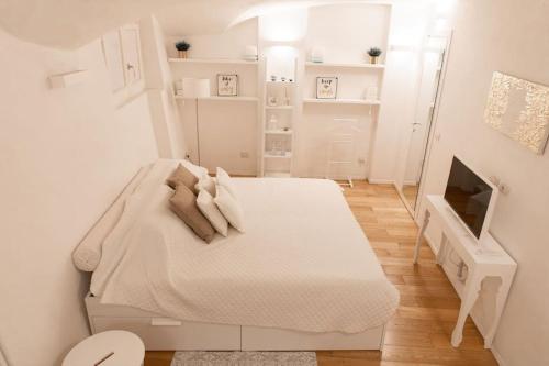 um quarto branco com uma cama e uma televisão em Bologna Boutique Home em Bolonha