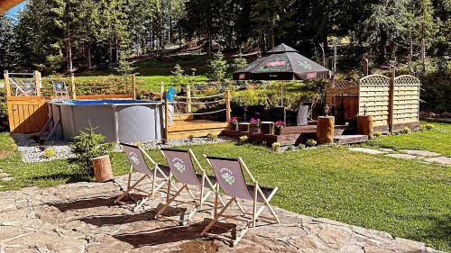 a group of chairs sitting in a yard with a gazebo at Domek w Górach- Bacówka u Dudka in Nowy Targ