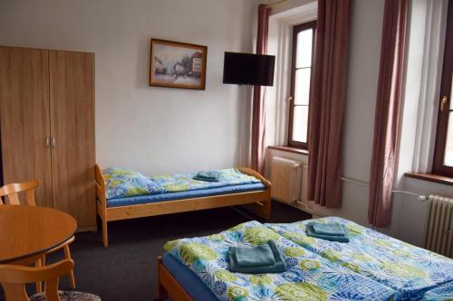 Cette chambre comprend 2 lits et une table. dans l'établissement Penzion Betty, à Okounov