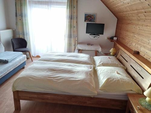 a bedroom with a large bed and a television at Haus Ferner-Lerchner in Mariapfarr