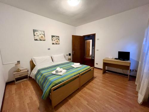 a bedroom with a bed with two towels on it at Hotel TEA DOLOMITI - Lago di Alleghe - Monte Civetta in Alleghe