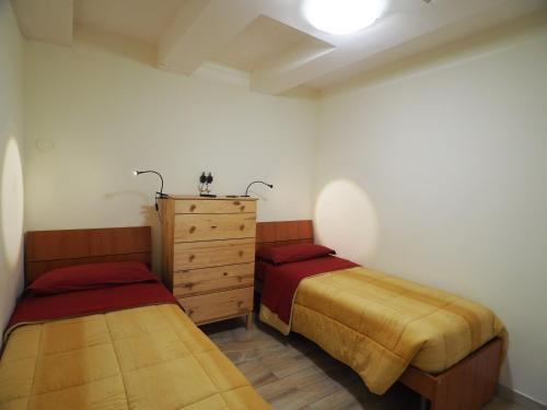 a bedroom with two beds and a dresser in it at Domus Toledo in Naples