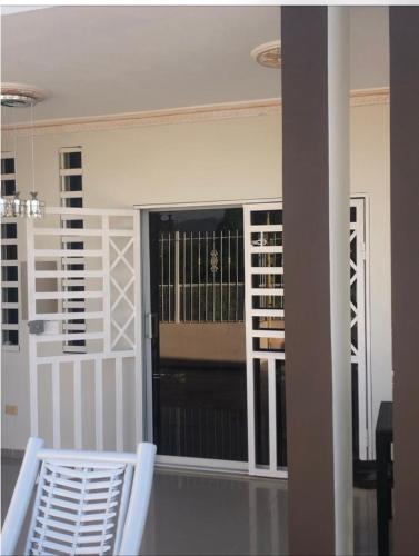 a room with two white chairs and a window at Pen House Vista Sur in Baní