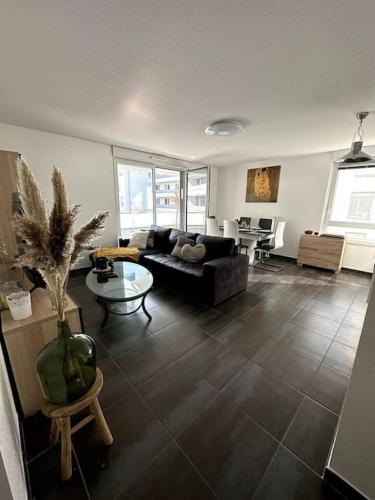 salon z kanapą i stołem w obiekcie Superbe appartement proche de Strasbourg w mieście Bischheim