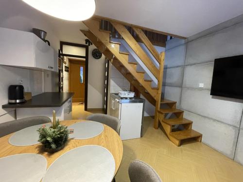 Habitación con mesa, sillas y escalera. en Modrzew, en Zakopane